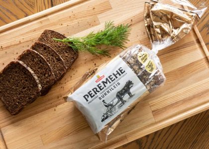 A top view of sliced rye bread with dill on a wooden tray, perfect for food photography.